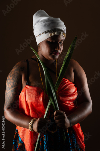 Картината върху платно Woman in traditional Candomblé clothing, holding the sword of Saint George plant