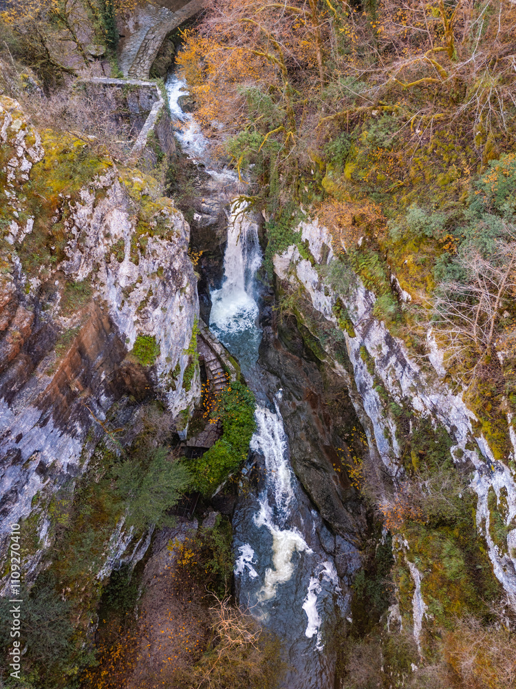 Obraz premium Aerial view of the waterfall at the ruins of Moulin du Saut, an abandoned 18th century water mill, near Gramat on the Alzou river in the Lot region of France