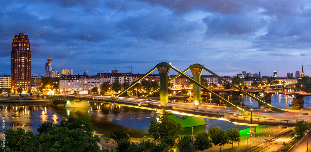 Obraz premium Evening view of Frankfurt and Flosserbrucke bridge over Main river