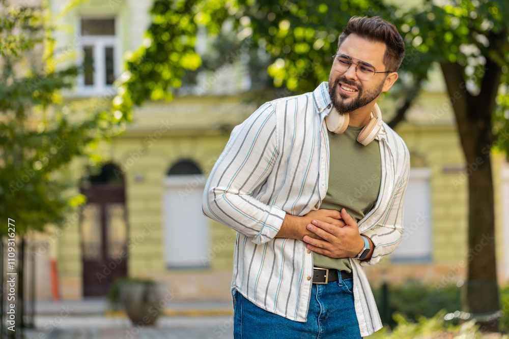 Caucasian young man traveler feeling sudden strong abdominal stomach ache gastritis problem. Upset tourist guy having symptom poisoning diarrhea indigestion peptic ulcer pancreatitis on city street. Caucasian young man traveler feeling sudden strong abdominal stomach ache gastritis problem. Upset tourist guy having symptom poisoning diarrhea indigestion peptic ulcer pancreatitis on city street.