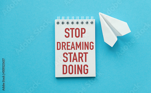 Stop Dreaming Start Doing Text written on notebook page on blue background photo