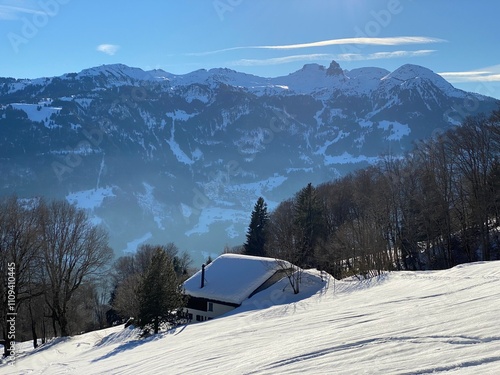 Old traditional swiss rural architecture and alpine livestock farms in the winter ambience over the Lake Walen or Lake Walenstadt (Walensee) and in Swiss Alps, Walenstadtberg - Switzerland (Schweiz) photo