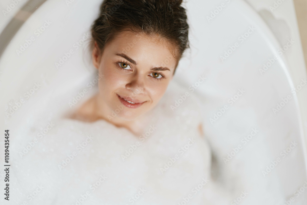 Relaxed young woman enjoying a bubble bath in a white tub, with a warm smile on her face, creating a serene and peaceful atmosphere. Self-care and wellness concept. Relaxed young woman enjoying a bubble bath in a white tub, with a warm smile on her face, creating a serene and peaceful atmosphere. Self-care and wellness concept.