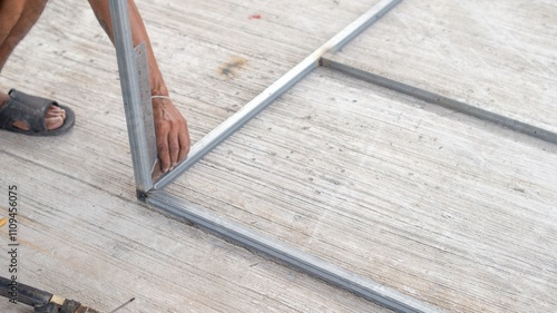 The technician uses an angle iron to measure the level of the steel.