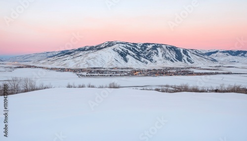 A serene winter landscape showcasing a snow-covered mountain at dusk.