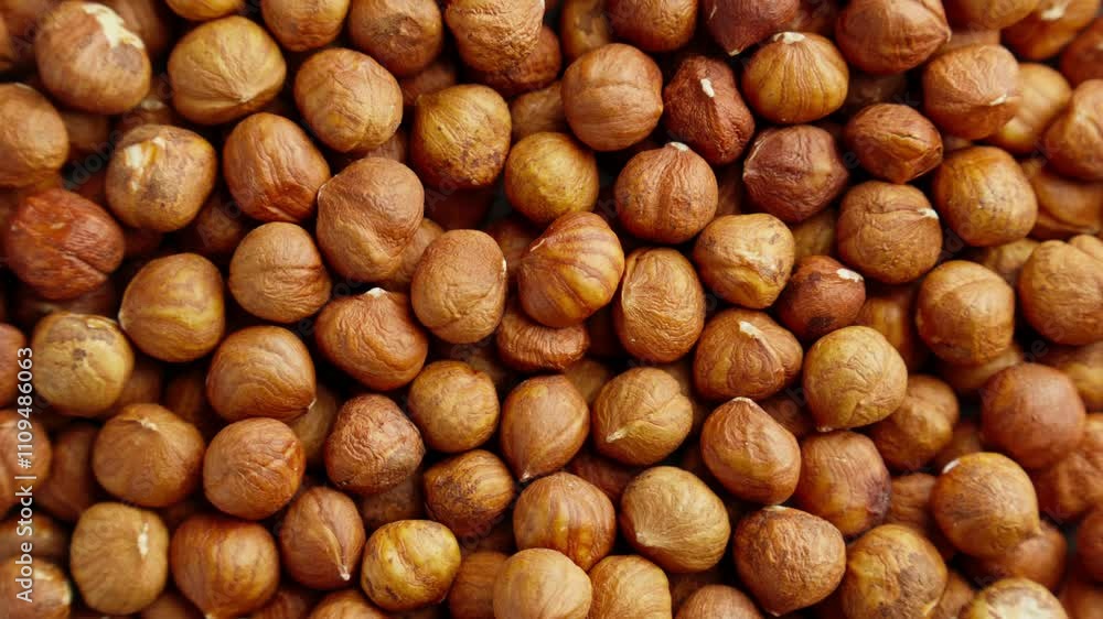 Pile of hazelnuts without shell rotating. Texture of hazelnut kernels. Natural vegetarian food. Vegan snack. Production line. Organic food. Close-up in 4K, UHD Pile of hazelnuts without shell rotating. Texture of hazelnut kernels. Natural vegetarian food. Vegan snack. Production line. Organic food. Close-up in 4K, UHD