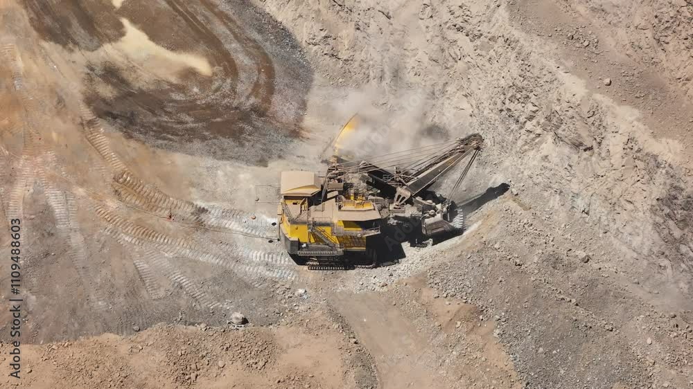 Aerial View of an Electric Mining Shovel Loading High-Tonnage Trucks at an Open-Pit Copper Mine in Chile - Heavy Machinery in Large-Scale Mining Operations Aerial View of an Electric Mining Shovel Loading High-Tonnage Trucks at an Open-Pit Copper Mine in Chile - Heavy Machinery in Large-Scale Mining Operations