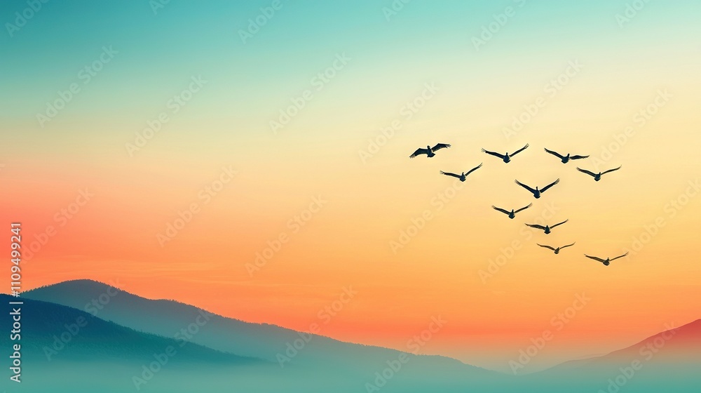 A group of birds soaring above mountains during sunset with a vibrant sky as backdrop A group of birds soaring above mountains during sunset with a vibrant sky as backdrop