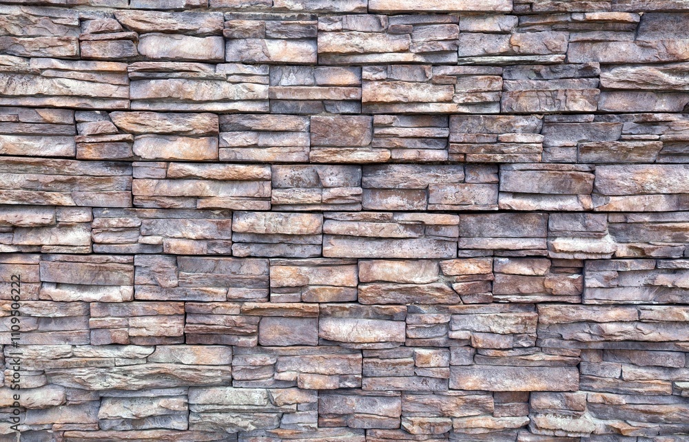Grayish brown stone external wall covering wall made of irregular bricks of natural rocks. Background and texture. Grayish brown stone external wall covering wall made of irregular bricks of natural rocks. Background and texture.