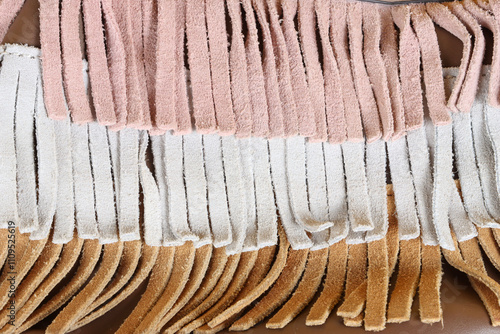 A close-up of fringe fabric texture in different colors, showcasing the soft suede material and vibrant hues