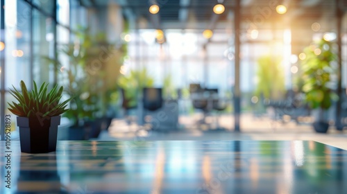 Blurred office interior background. Empty light open space office with big windows, many glasses walls, desks, chairs and green plants. Modern indoor business environment