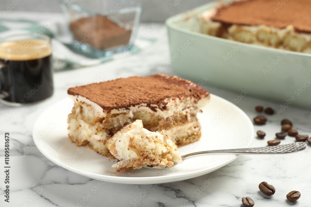 Piece of tasty tiramisu on white marble table, closeup Piece of tasty tiramisu on white marble table, closeup