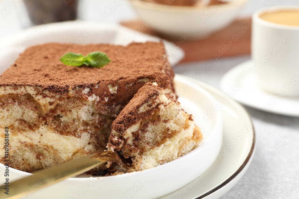 Delicious tiramisu with mint on light table, closeup Delicious tiramisu with mint on light table, closeup