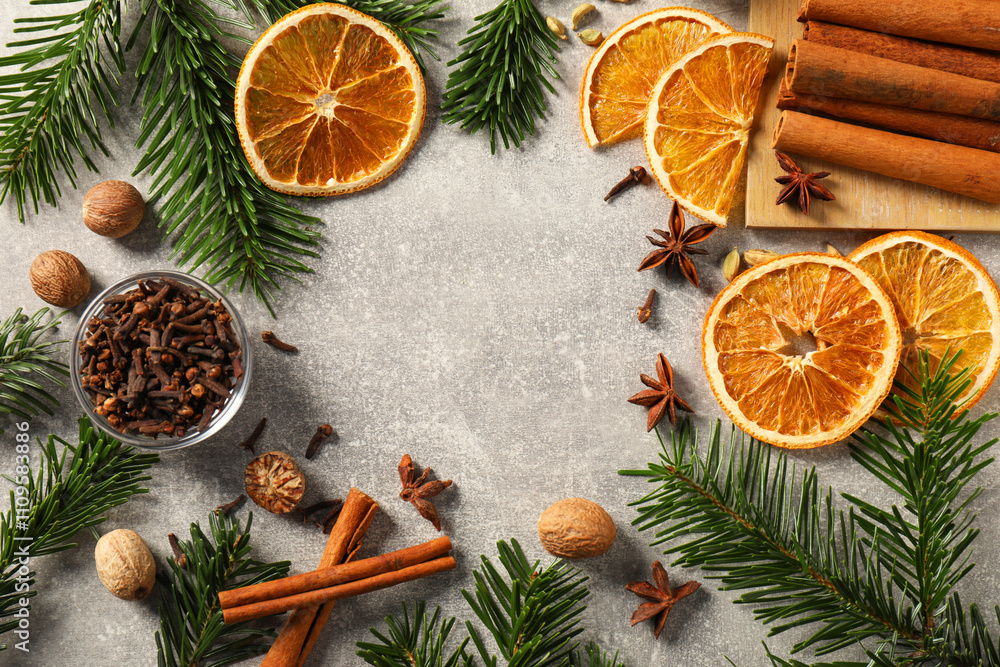 Different spices, dried orange slices and fir tree branches on light grey table, flat lay with space for text. Christmas season Different spices, dried orange slices and fir tree branches on light grey table, flat lay with space for text. Christmas season