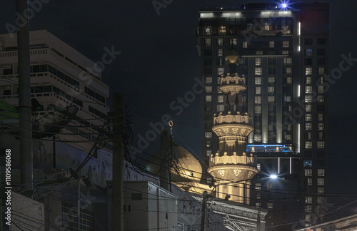 Architecture exterior of Mirasuddeen mosque with modern building in the background. photo