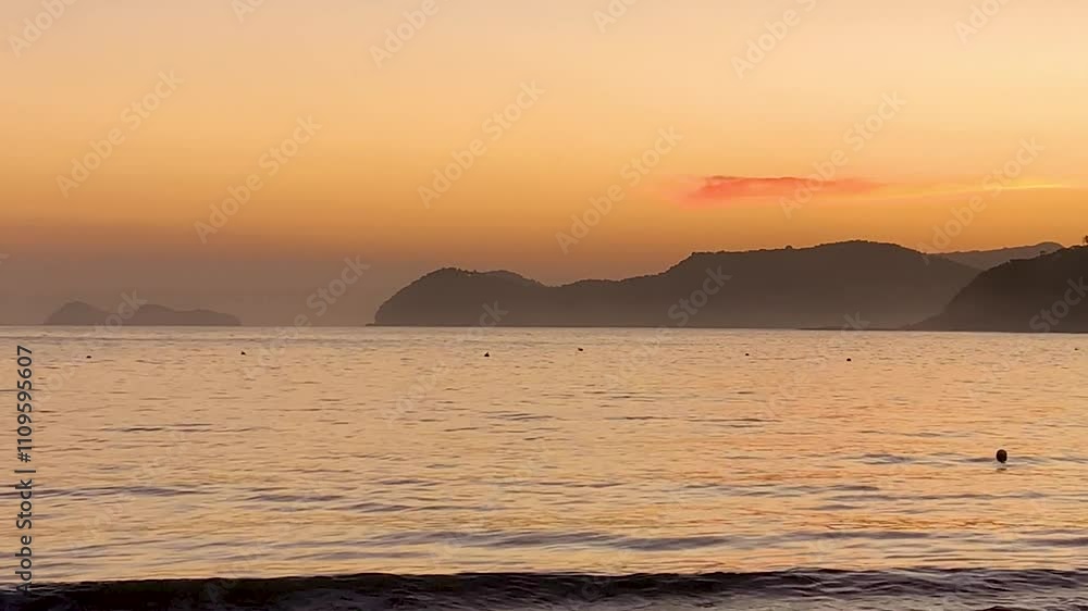 Final de tarde em tom laranja. O mar bem calmo e ao fundo, a Final de tarde em tom laranja. O mar bem calmo e ao fundo, a