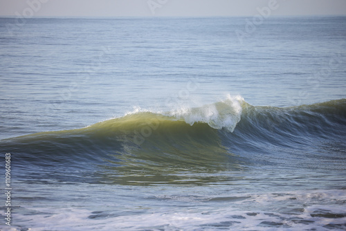 A peaceful ocean wave caught mid-break, showcasing the serene motion of water. Perfect for coastal vibes, relaxation themes, or marine and beach-related designs
 photo