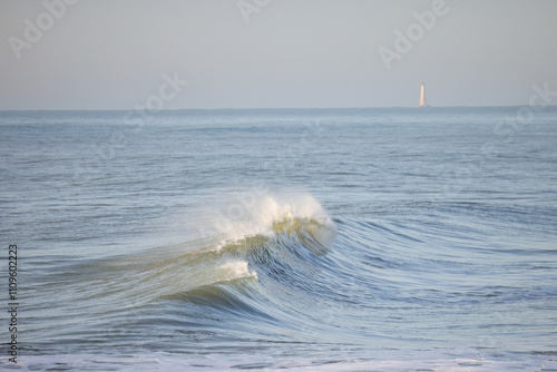 A peaceful ocean wave caught mid-break, showcasing the serene motion of water. Perfect for coastal vibes, relaxation themes, or marine and beach-related designs
 photo