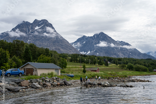 Svensby, Norway - 07.08.2024: Mountains, fjord and blue sky in Norwegian landscape in Svensby port, Norway photo