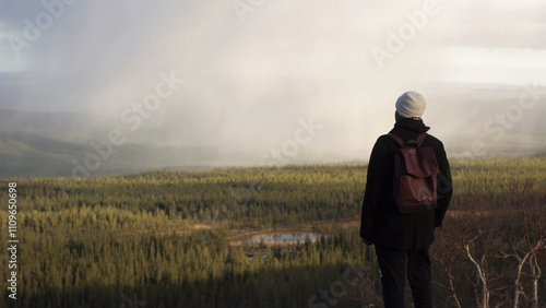Photography Man in dark clothes looks over mountain landscape, Sweden