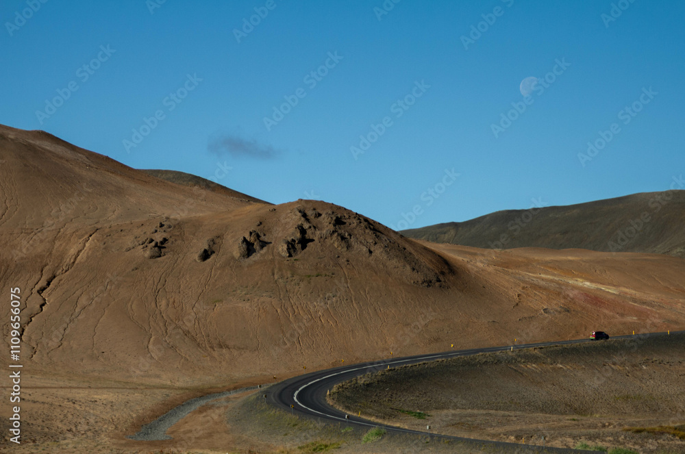 A breathtaking Icelandic landscape with towering mountains, fields, and vibrant red ground A breathtaking Icelandic landscape with towering mountains, fields, and vibrant red ground