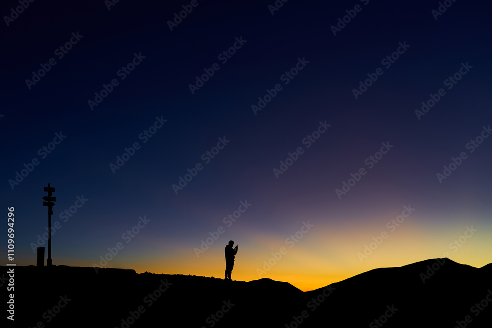 Obraz premium Man standing at the top of mountain range, freedom and peace concept. Gradient sky