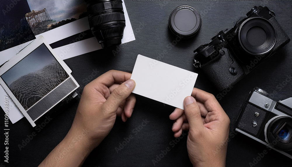 Obraz premium Business card mockup showcased on a flat lay of printed photos and camera equipment on a black surface