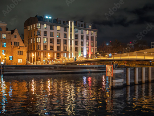 Budynek nad rzeką, oświetlony neonami. Gdańsk