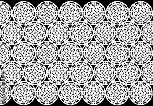 Fabric of white circles, on a black background, crochet, symmetrical pattern.