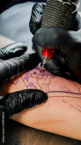 Tattoo artist creating a design with a machine on human skin