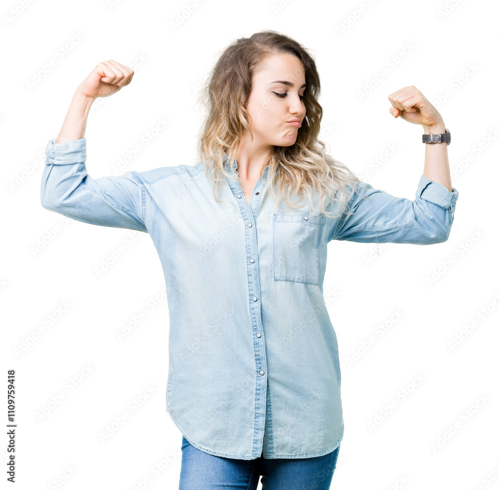 Obraz premium Beautiful young blonde woman over isolated background showing arms muscles smiling proud. Fitness concept.