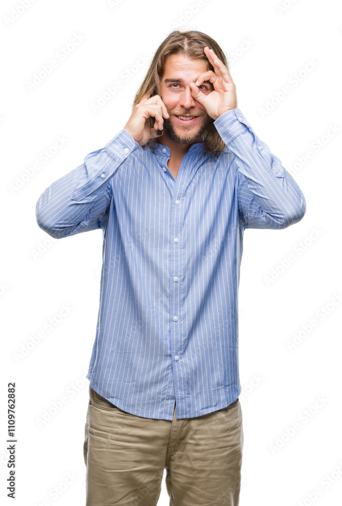Young handsome man with long hair over isolated background talking on the phone with happy face smiling doing ok sign with hand on eye looking through fingers Young handsome man with long hair over isolated background talking on the phone with happy face smiling doing ok sign with hand on eye looking through fingers