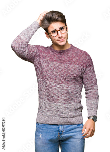 Young handsome man wearing glasses over isolated background confuse and wonder about question. Uncertain with doubt, thinking with hand on head. Pensive concept. photo