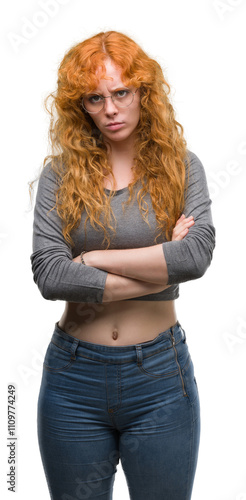 Young redhead woman skeptic and nervous, disapproving expression on face with crossed arms. Negative person.