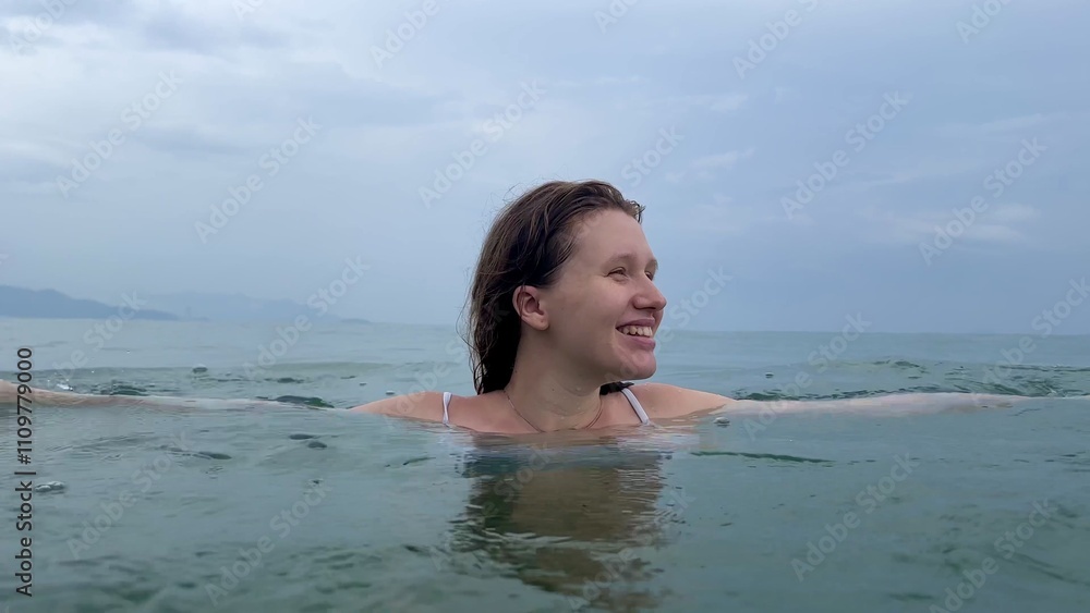 Young beautiful happy woman swimming in the sea, ocean, summer vacation on the beach Young beautiful happy woman swimming in the sea, ocean, summer vacation on the beach