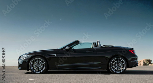Sleek black convertible car against a clear blue backdrop, automotive elegance
