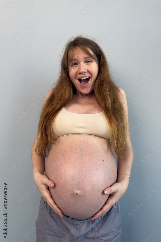 Happy pregnant young woman on gray background in lingerie Happy pregnant young woman on gray background in lingerie