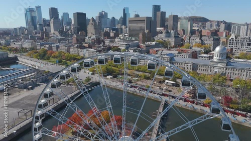 Soar above Montreal's iconic landmarks with this stunning aerial drone footage. The clip captures a mesmerizing flight passing over a gigantic Ferris wheel, gliding gracefully into the city skyline.