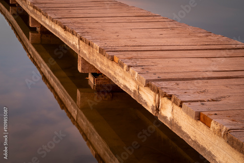 Valokuvatapetti wooden footbridge over a lake in sunset light