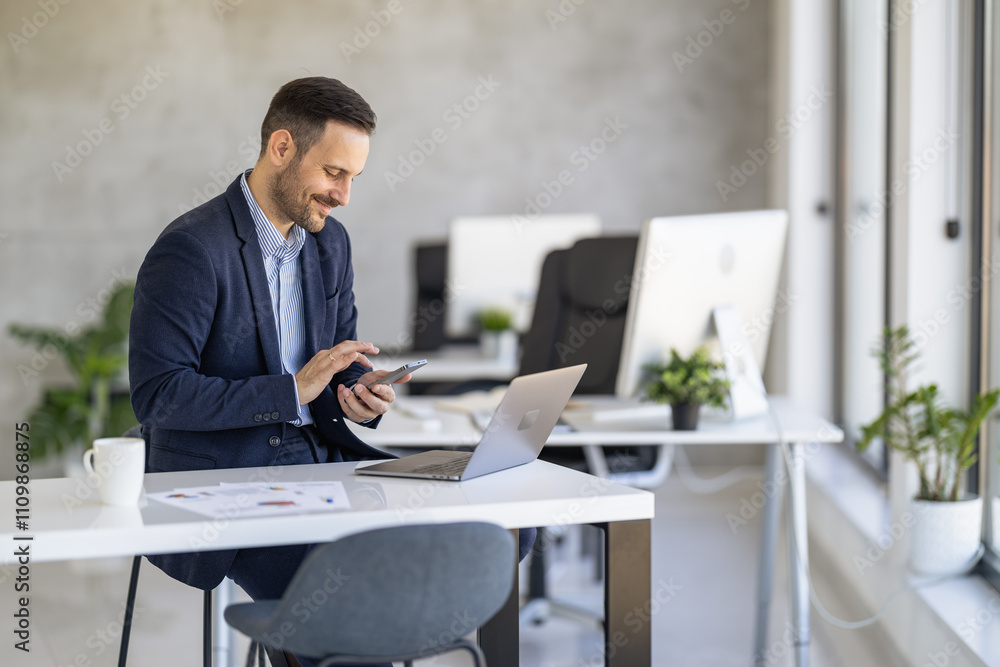 Professional Man Using Smartphone and Laptop in Modern Office Professional Man Using Smartphone and Laptop in Modern Office