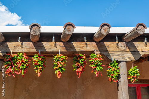 Dried Red and Green Hatch Chiles Hanging from Support Beams on an Adobe Mud Brick Building, Albuquerque, New Mexico, United States photo