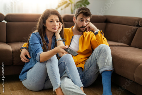 Bored Couple Watching TV Together on a Cozy Sofa photo