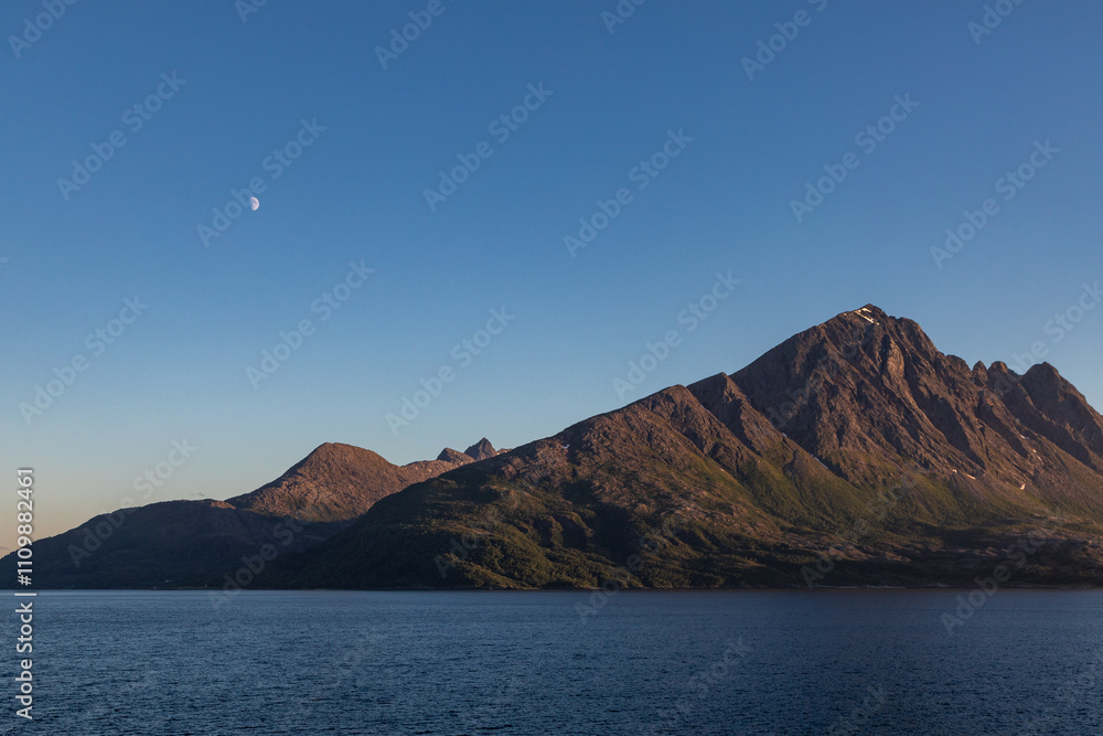 Moonrise at Sea Over the Mountains During Mid Summer in Norway When the Sun Never Sets, From the Deck of a Cruise Ship Moonrise at Sea Over the Mountains During Mid Summer in Norway When the Sun Never Sets, From the Deck of a Cruise Ship