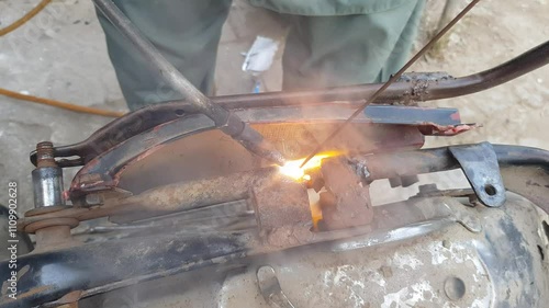 Welding Repair on Rusty Motorcycle Frame with Spark photo