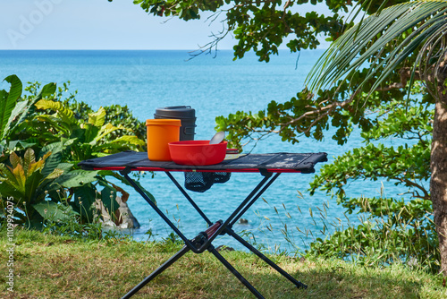 ultralight kitchen set for traveling on a folding table, in nature with a tropical view