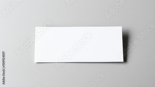 A blank white card resting on a gray surface, ready for your message or design.