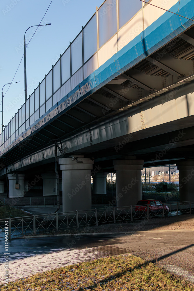 Fragment of a multi-level highway interchange with one road passing under another, supported by concrete columns, urban infrastructure. Fragment of a multi-level highway interchange with one road passing under another, supported by concrete columns, urban infrastructure.