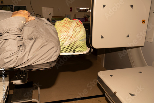 Senior male with skin cancer receiving radiation in a radiotherapy thermoplastic mask which immobilises the head.