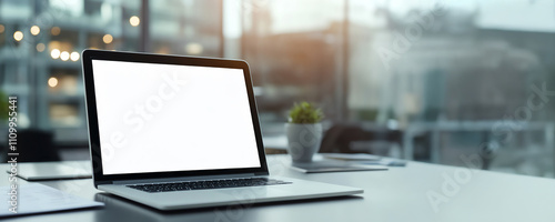 A laptop with a blank screen on a modern office desk, with a blurred window background. Perfect for business presentations and mockups.