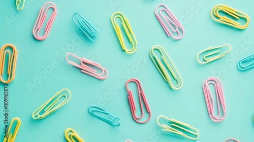 Flat lay gradient of paper clips transitioning seamlessly across vibrant colors on aqua